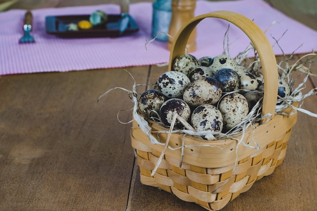 Quail eggs in bamboo basket On the old wood table background.