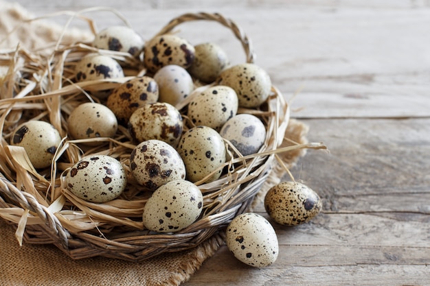 Quail eggs in a basket on a wooden table