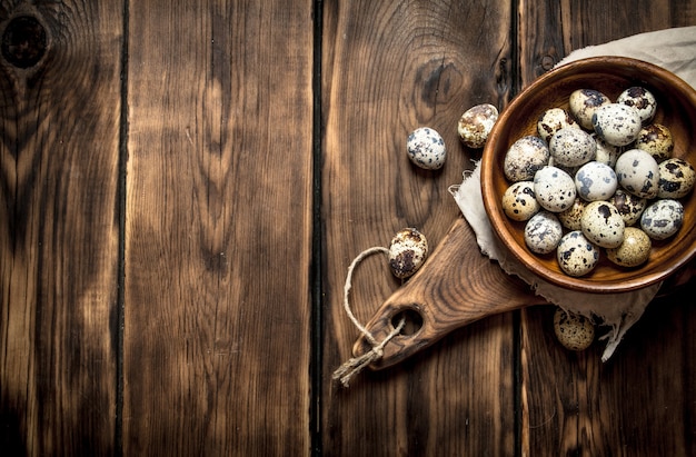 Quail eggs in bowl on wooden table