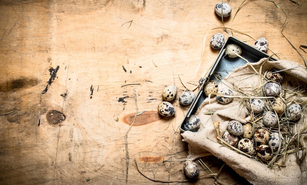 Quail eggs in the box. On wooden table.