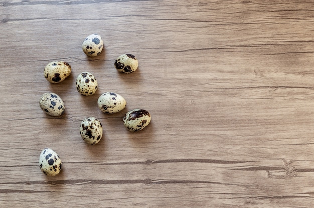 Quail eggs on brown wooden background. Flat lay, top view. Easter concept. 