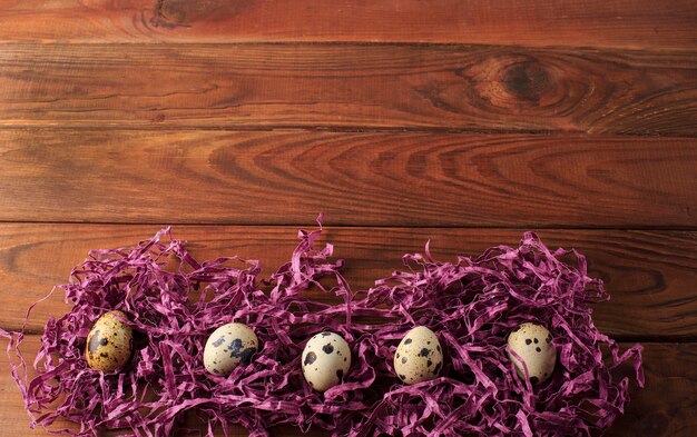 Quail eggs on the brown wooden table. Easter table.