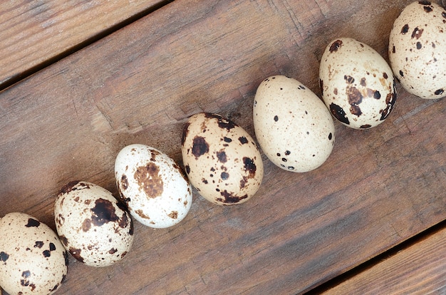 Quail eggs on a dark brown wooden surface