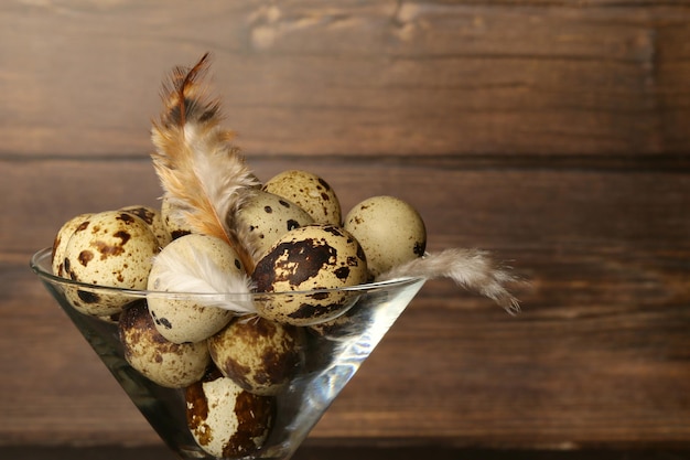 Quail eggs in a glass on a wooden background