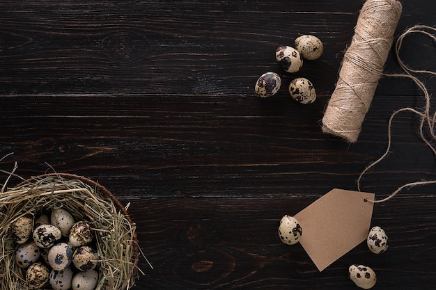 Quail eggs in a nest place for text on wooden rustic background top view close up