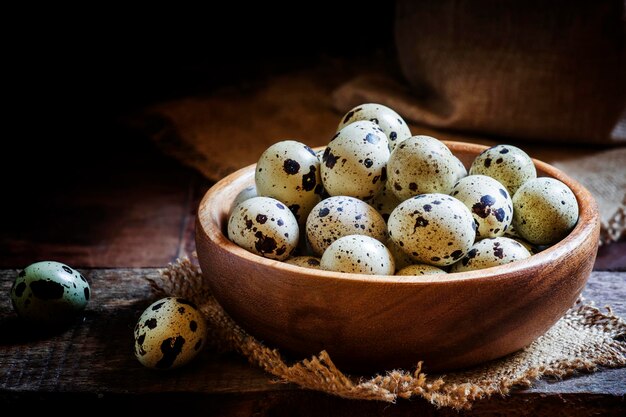 Quail eggs old wooden background low key selective focus