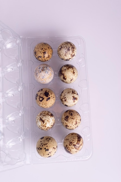 Quail eggs in packaging on a white table