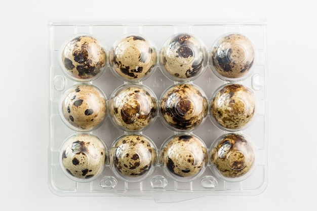 Photo quail eggs in plastic package. organic product.