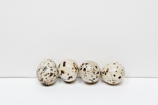 Quail eggs in a row on white