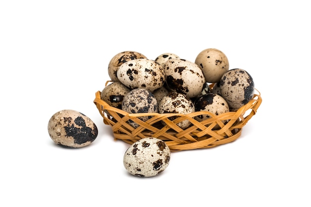 Quail eggs in wicker basket on white background