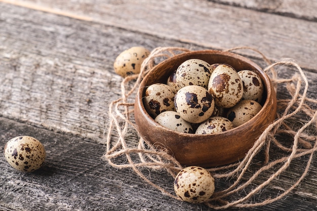 Quail eggs in wooden bowl.