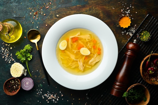 Quail soup Quail meat broth with quail eggs and noodles In a white plate Top view