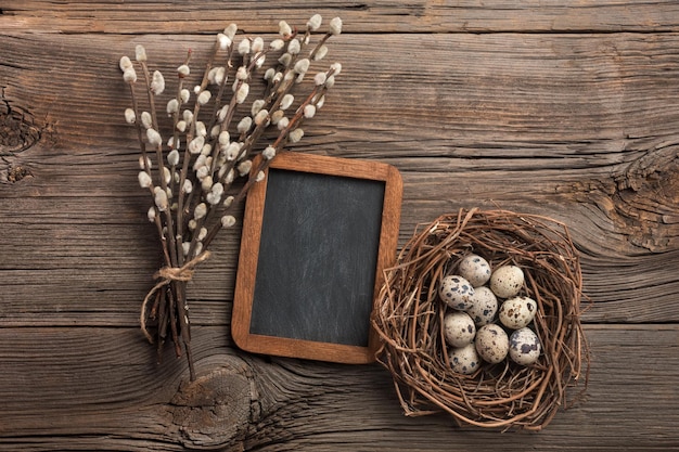 Quails eggs in nest and flowers Easter greeting card Top view with space for your greetings