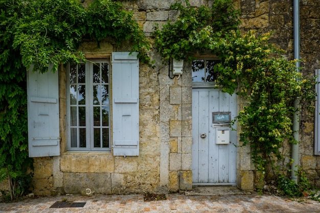 Quaint and flowery facades of townhouses with colorful wooden shutters and doors in Terraube (Gers)