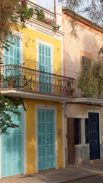 Quaint house with a yellow facade and light blue doors and windows