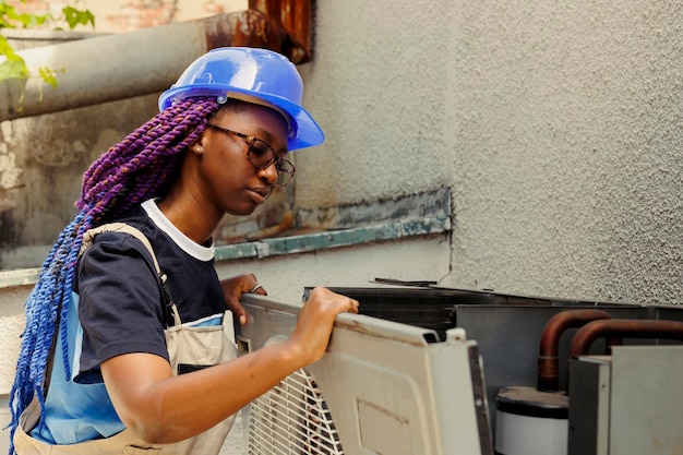 Photo qualified expert taking apart rusty condenser front grill in order to start reconditioning damaged internal parts skilled professional employed by customer to do checkup on hvac system