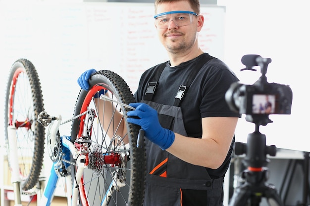 Qualified handyman fixing broken bicycle filming process on videocamera