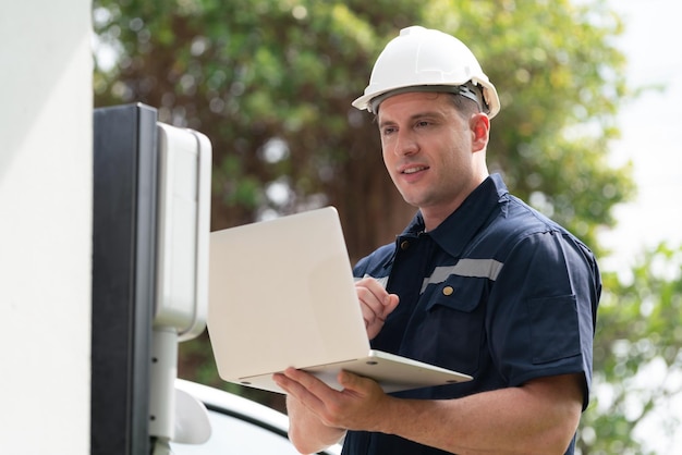 Qualified technician working with laptop for home EV station Synchronos