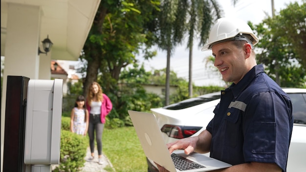 Qualified technician working with laptop for home ev station synchronos