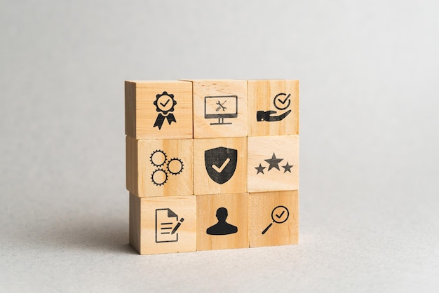 Quality, standards, rating and management concept on wooden cubes with icons.