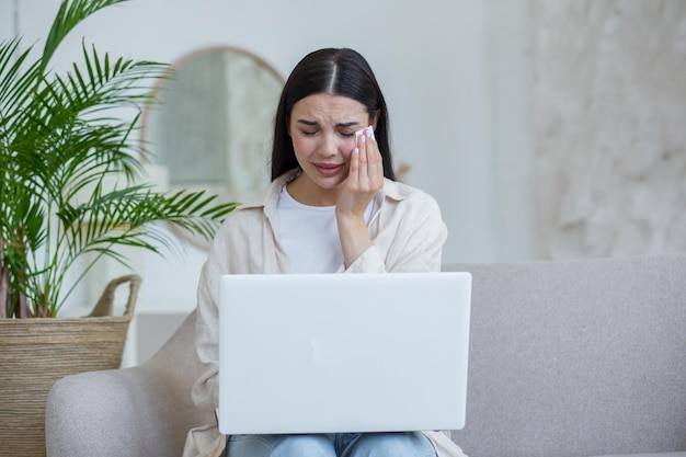 Quarantaine oorlog een mooie jonge vrouw zit thuis op de bank met een laptop praat online via