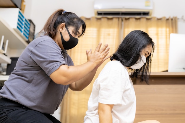 Foto la donna asiatica in quarantena fa il massaggio a casa con la maschera