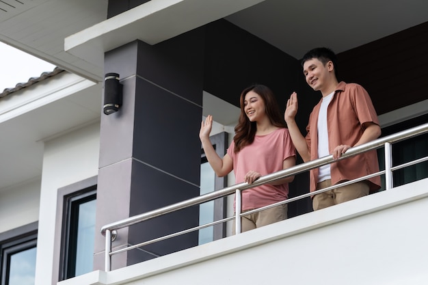 Quarantine couple greeting neighbors from balcony of the home, coronavirus pandemic