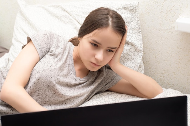 Quarantine and isolation Young girl works at home at a laptop sits in an apartment