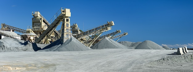 quarry machines and piles of gravel over blue sky stone crushing and screening plant panorama