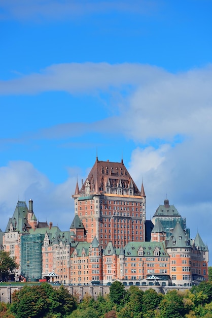 Quebec City skyline over river with blue sky and cloud.