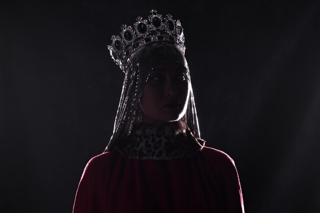 queen with crown studio portrait on a black background