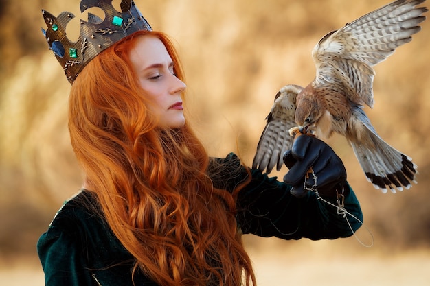 Queen with red hair in a green dress with a crown with a bird