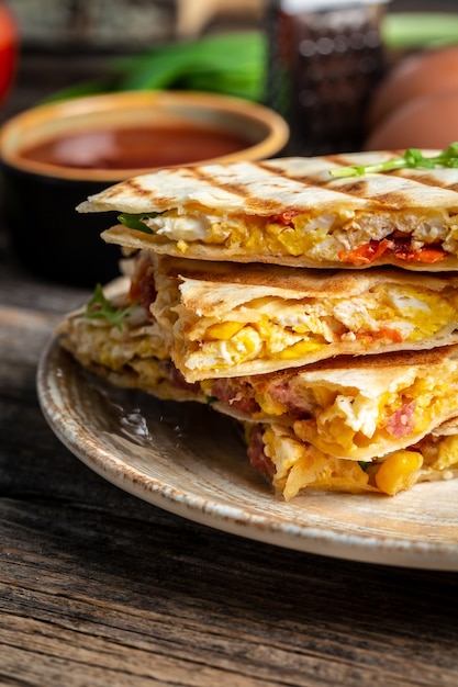 퀘사 디아 스크램블 드 에그, 야채, 햄, 치즈를 곁들인 전통적인 멕시코 토르티야
