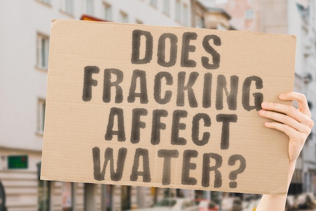 Photo the question does fracking affect water on a banner in men's hands with blurred background climate ecological business ecologic safety drill nature geology caution health healthiness