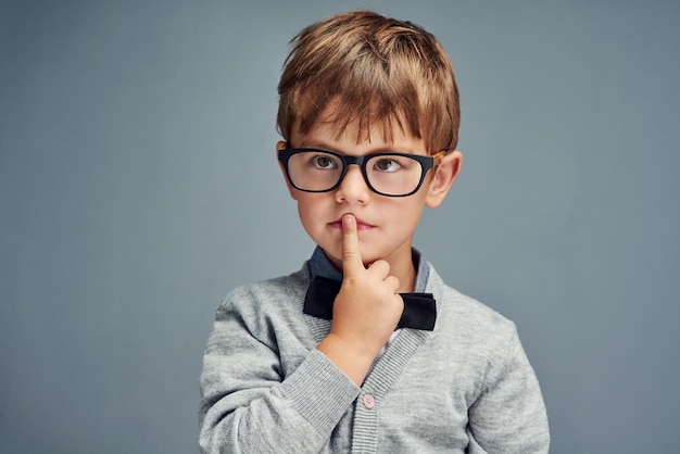 Question everything Studio shot of a smartly dressed little boy looking thoughtful against a gray background