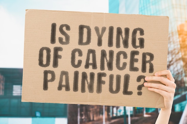 The question Is dying of cancer painful on a banner in mens hand Pain Sickness Despair Death