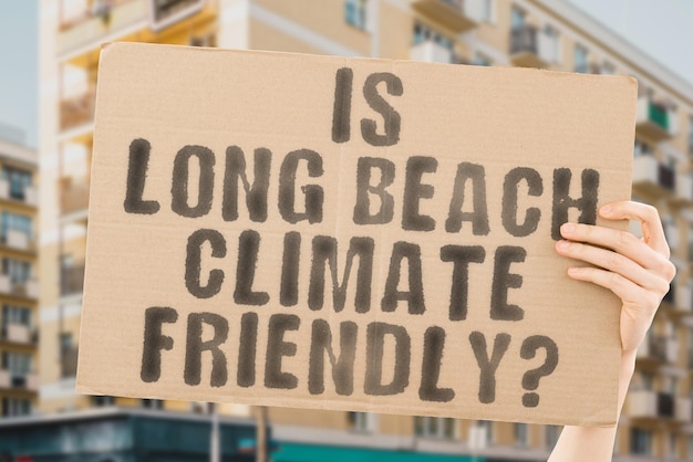 The question is long beach climatefriendly is on a banner in\
men\'s hands with blurred background support team activist urban\
sunset carbon ecology energy new clean warming waste