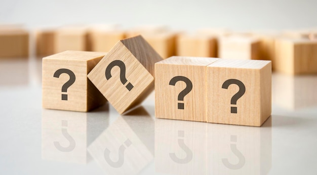 Question mark shown on four wooden cubes on a grey background