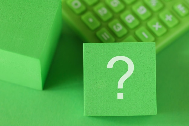 Question mark sign on block cube green calculator on green background ESG support concept