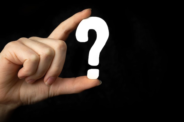 Question mark sign in hand. question icon, symbol on a black\
background. concept of doubt, education or faq