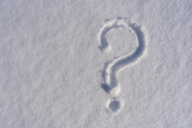 Question mark on a white fresh snow in winter close up