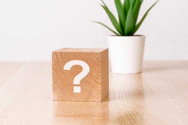 Question mark on wooden cube on the table