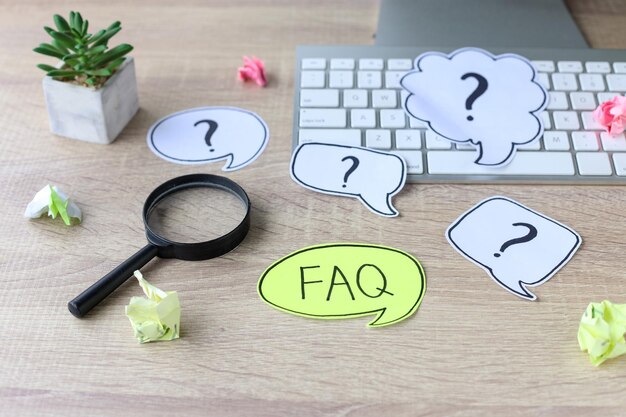 Question mark and word FAQ on office desk. Working with clients. Troubles in work.