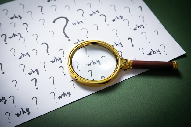 Question marks and Why word with magnifying glass