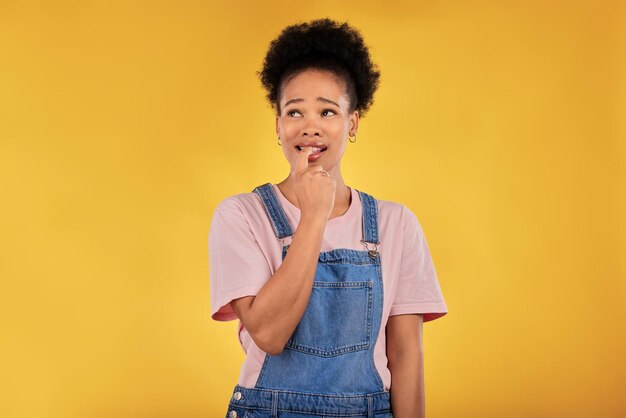 Question thinking and woman with anxiety nervous and decision against a yellow studio background female person why and model confused anxious and biting nails with depression stress and fear