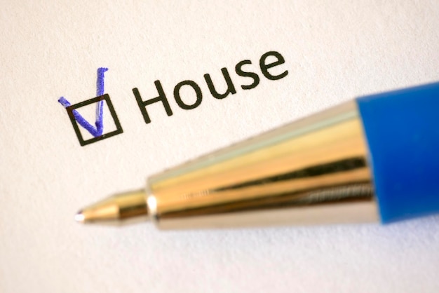 Photo questionnaire blue pen and the inscription house with check mark on the white paper