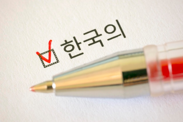 写真 アンケート 赤ペンと白い紙に十字の付いた korean の碑文