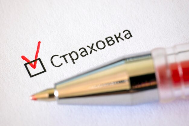 Questionnaire Red pen and the inscription INSURANCE with check mark on the white paper