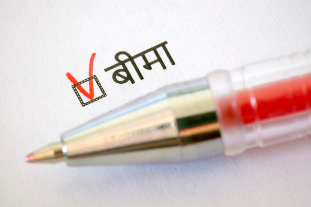 Questionnaire red pen and the inscription INSURANCE with check mark on the white paper