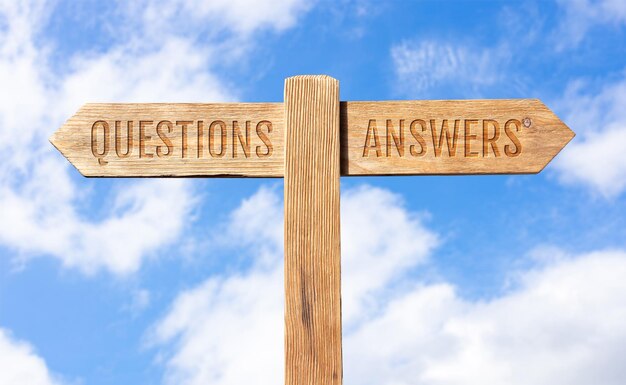 Questions or Answers concept Wooden signpost with message on sky background